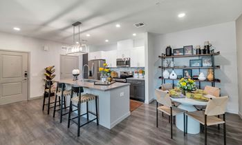 a kitchen and dining room area with a table and chairs and a refrigerator at Weylyn Luxury Apartments, Laveen, 85339